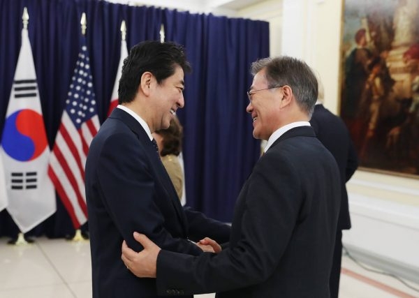 安倍首相と握手する韓国の文在寅大統領。初めての顔合わせだった。写真は青瓦台提供。