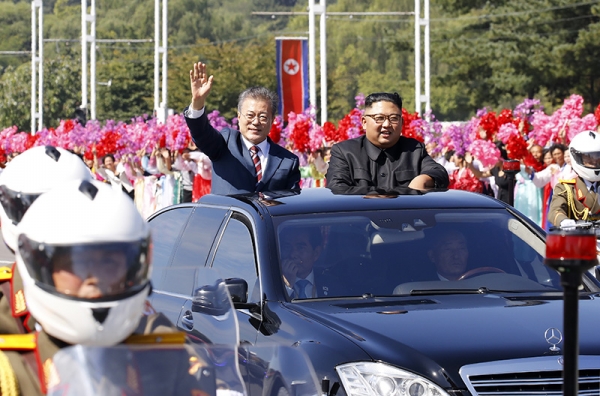 19日午前、平壌市内でカーパレードを行う南北首脳。10万人を超える北朝鮮の市民が出迎えたとされる。写真は平壌写真共同取材団。
