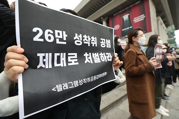 （ソウル＝聯合ニュース）「テレグラム性搾取共同対策委員会」が26日、ソウル市内で記者会見を開いた。写真の参加者のプラカードには「26万人の性搾取共犯、しっかりと処罰せよ」と書かれている。