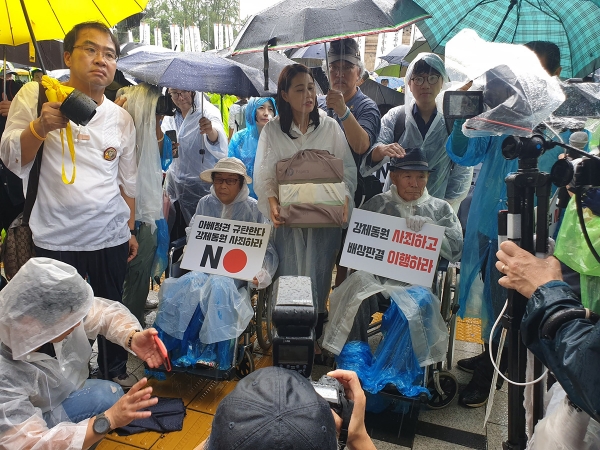 昨年8月、ソウルの日本大使館前で判決の履行を求めるデモを行った原告の李春植（イ・チュンシク）さん(中央右)。筆者撮影。