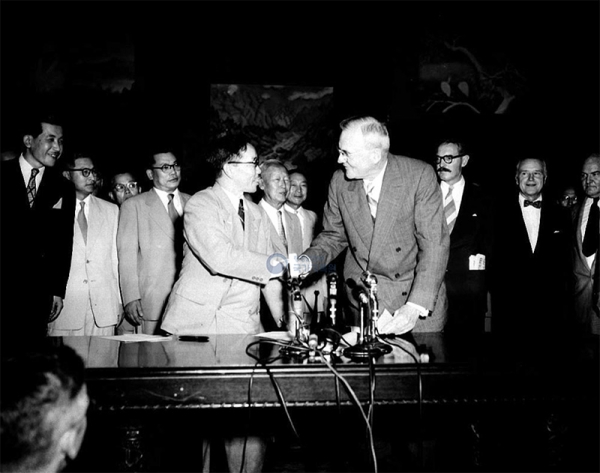 1953年8月、ソウルで行われた条約の仮調印式で握手する卞榮泰（ピョン・ヨンテ）韓国外交部長官とJohn Foster Dulles米国務長官。韓国国家記録院より引用。